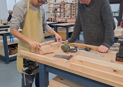 Student getting advice from woodworking instructor about his project