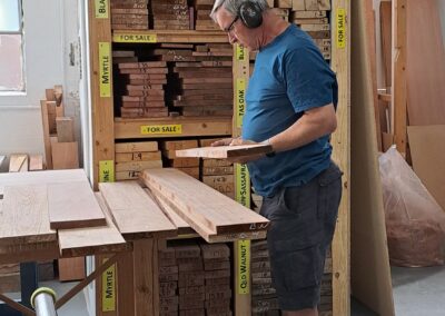 Furniture Making student looking at timber board deciding which he will purchase